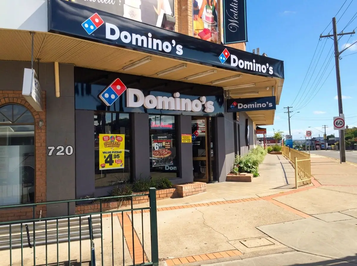 Domino's Guildford corner shopfront with illuminated fascia and under-awning signage